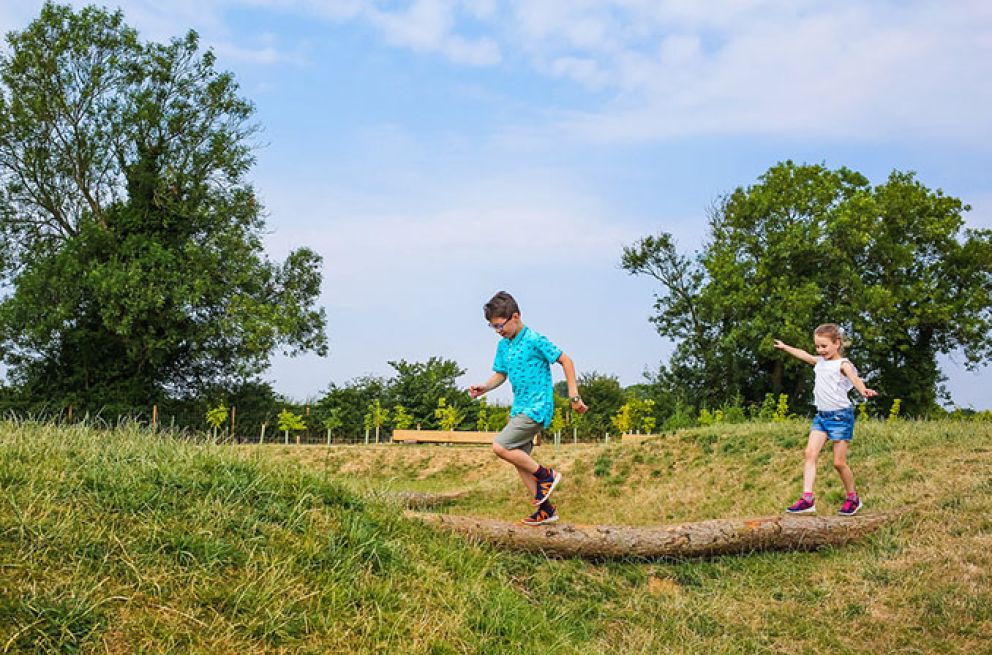 Kids playing on a log at Willian's Den