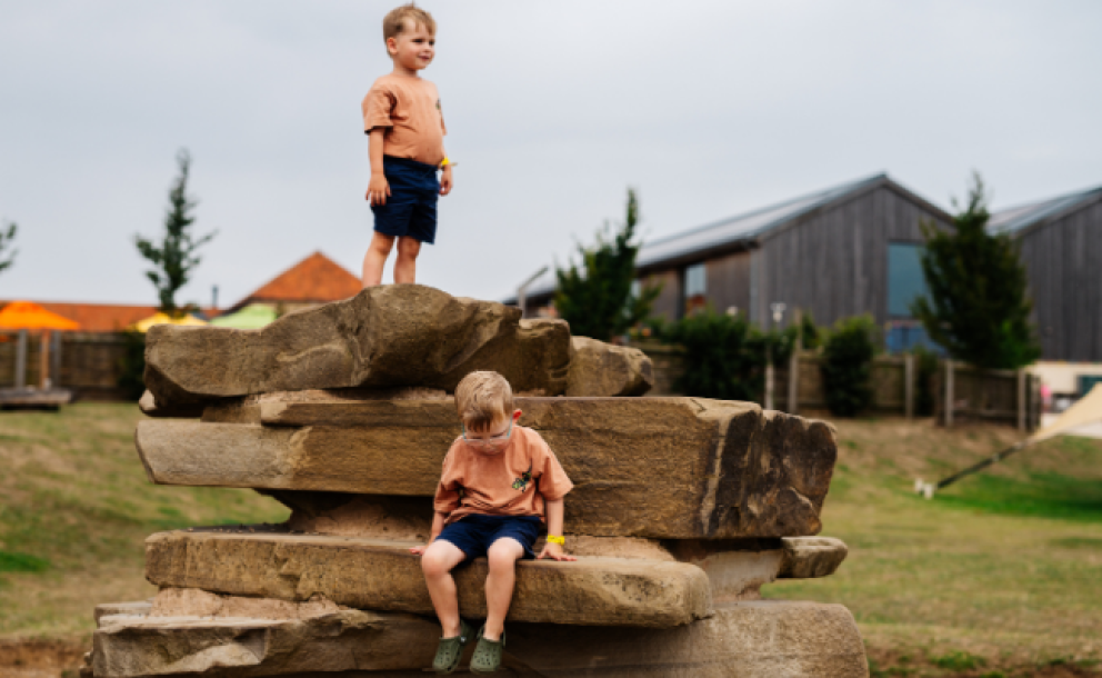 little boys climbing on stacked rock